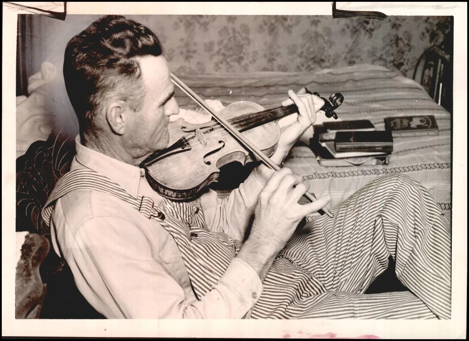 Photograph used for a story in the Daily Oklahoman newspaper. Caption: "A Hughes county farmer of the Lamar area, who four years ago became attached to an old Violin left by the previous occupants in New Mexico farmhouse which he rented, today looks upon it as his fondest possession."