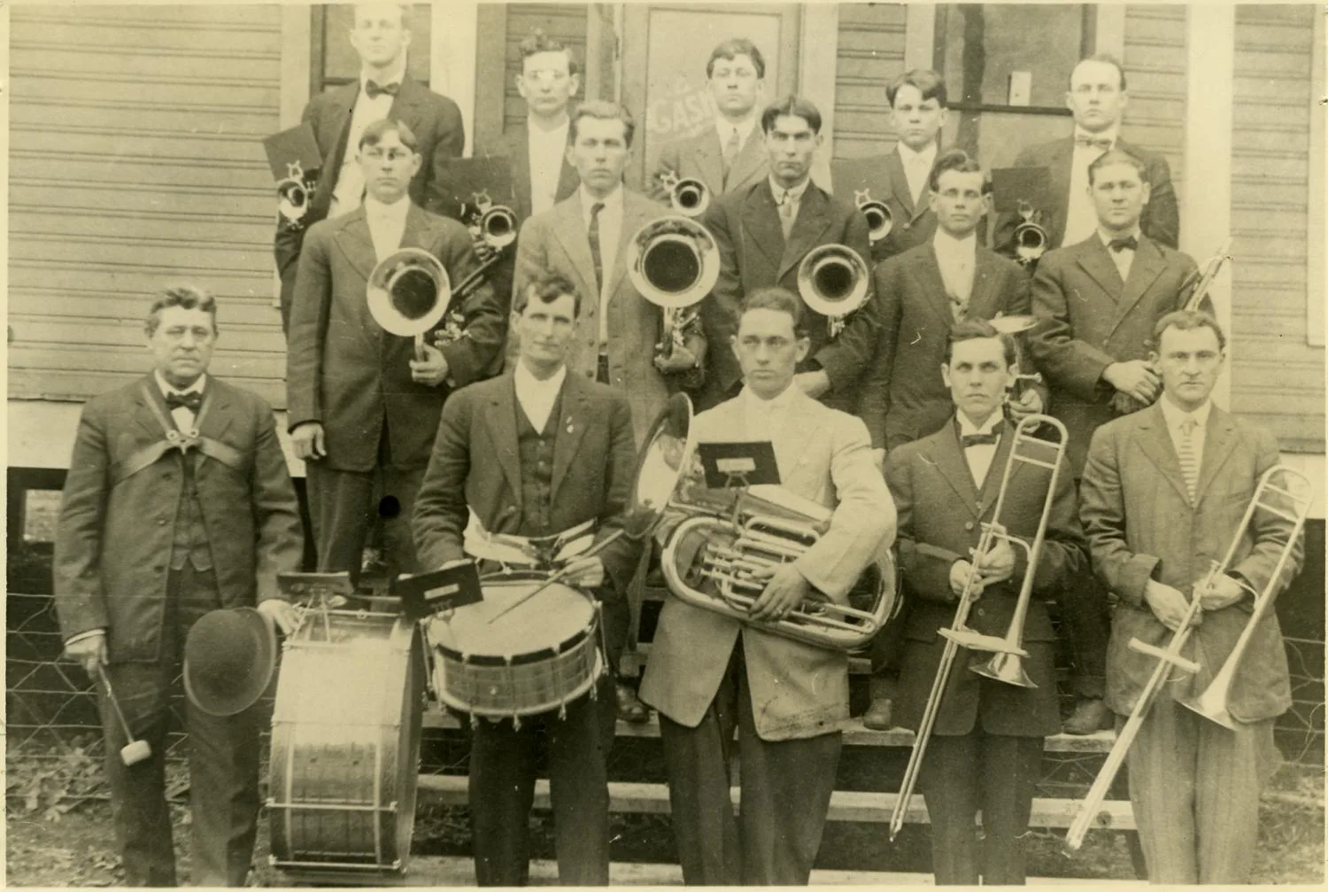 Photograph of Bismark band posed as a group outside of a building. First row left to right: J.B. Gresham, ___,____, L.P. Bonnett, __. Second row: Sam Gresham, ___,____,____, George Gresham. Third row: ____,____, Bob Gresham, ____, and Louis Dollarhide.