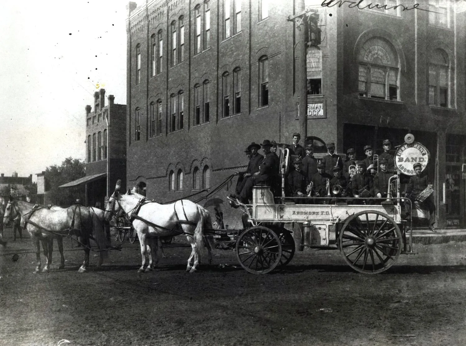 The first Regiment Band aboard a fire department wagon ready for a parade. L.C. Slaughter, Fire Chief, Holds the reins of the four horse team.