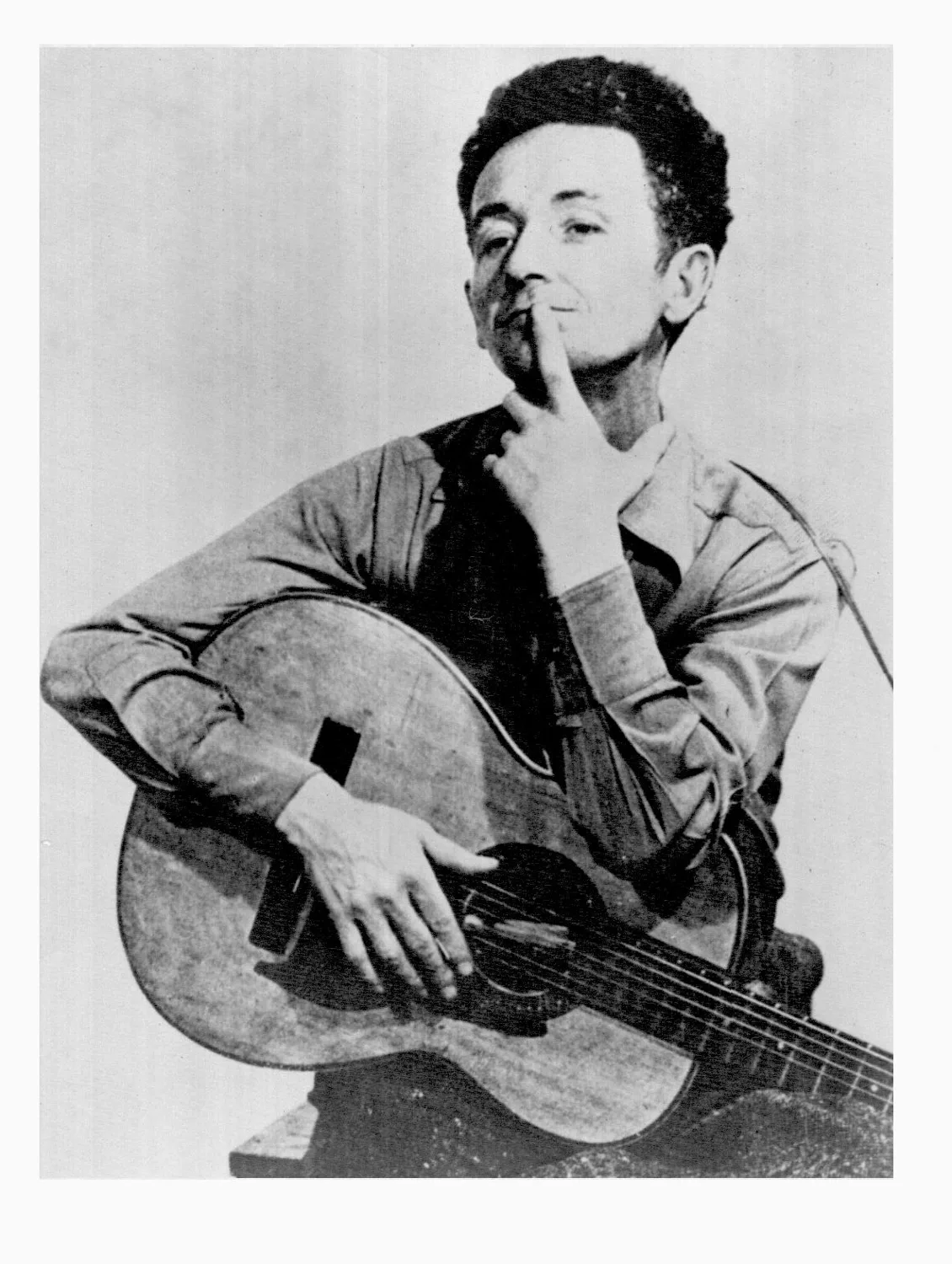 Guthrie Woody \ Photo of Woody Guthrie with guitar.