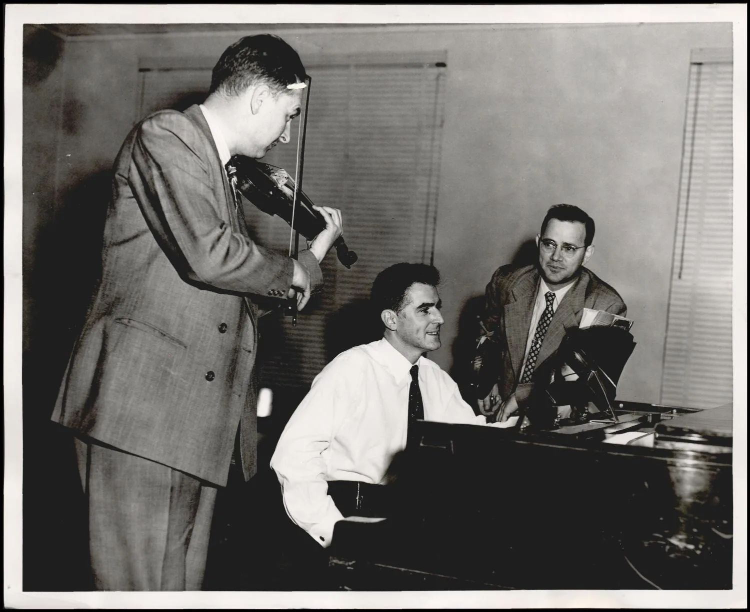 Photograph used for a newspaper owned by the Oklahoma Publishing Company. Caption: "From left, J.M. Brakebill, concertmaster of the Northwestern Symphony; violin teacher Robert Rudie; and Dr. K.A. Fite, Northwestern State College music dept. head."