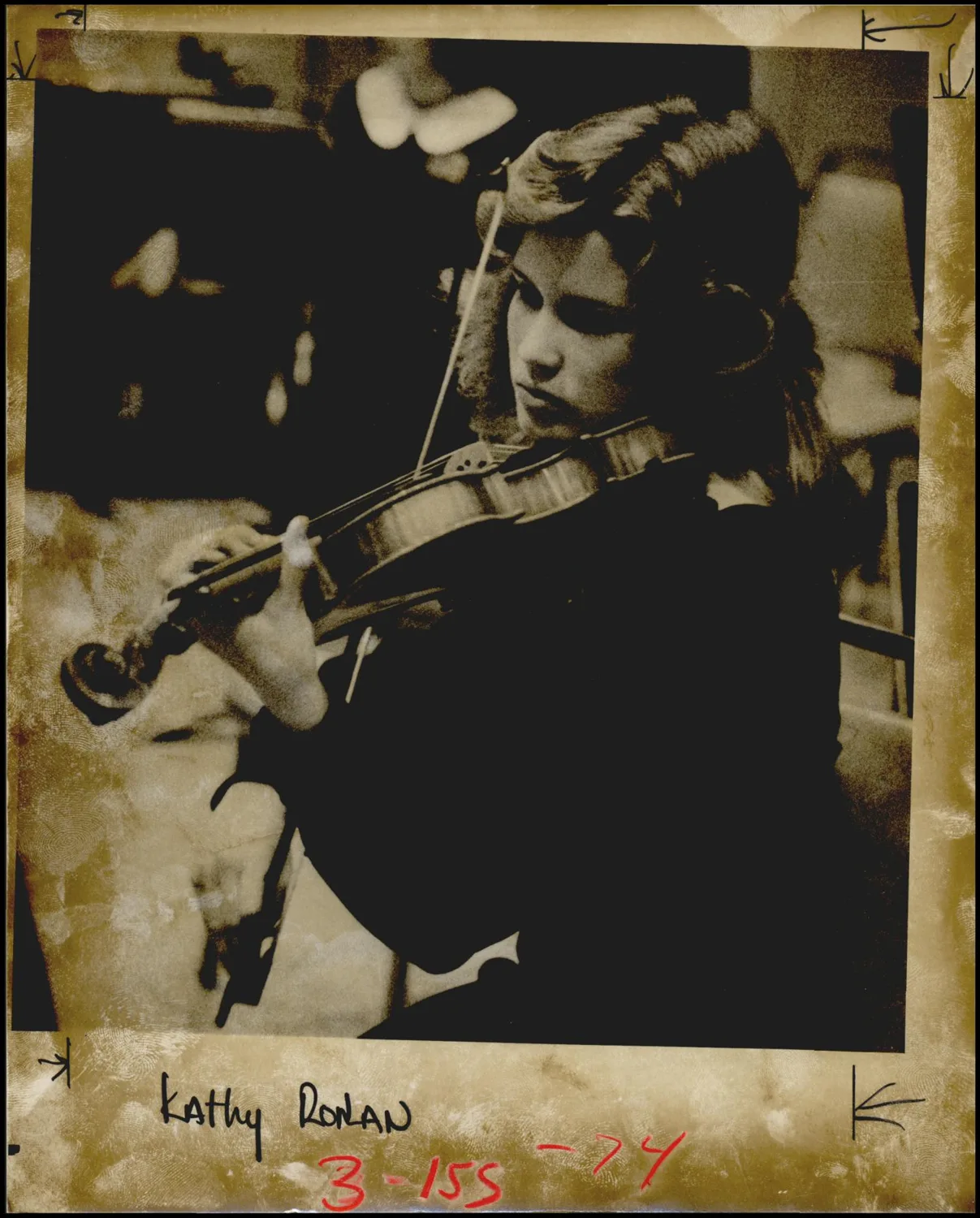 Photograph used for a newspaper owned by the Oklahoma Publishing Company. Caption: "Ponca City's Kathy Ronan tunes up her violin."