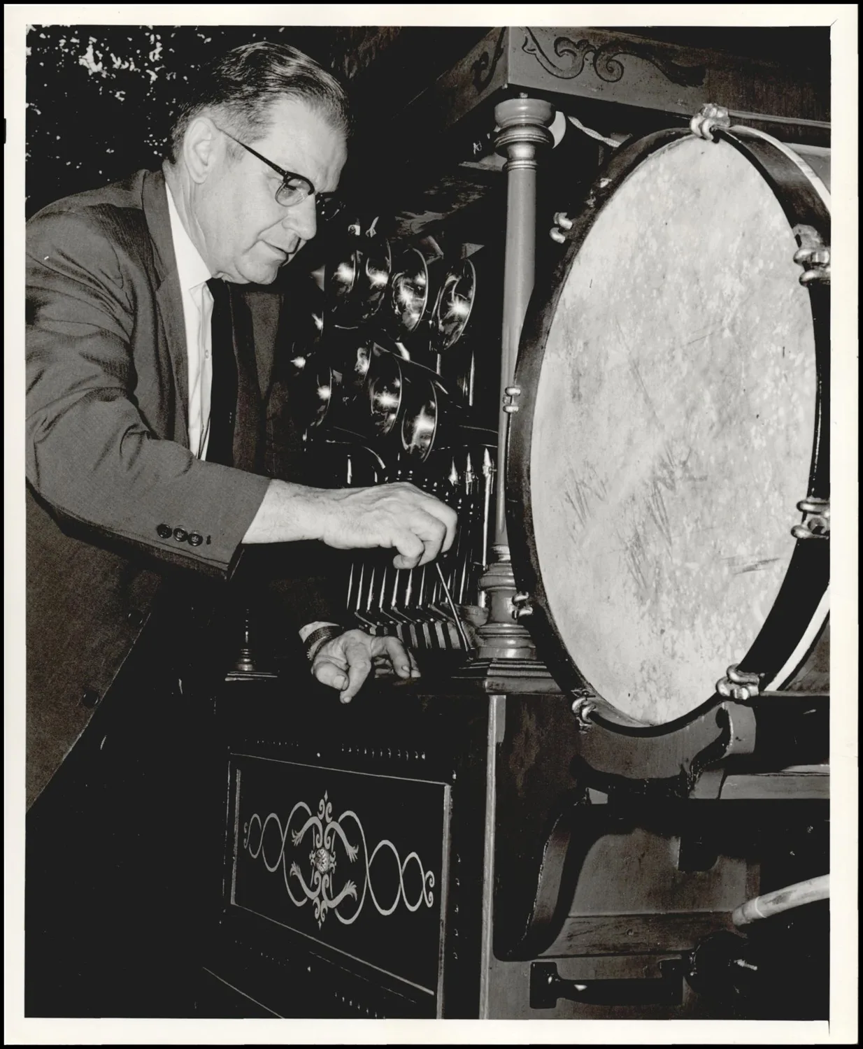 Photograph used for a newspaper owned by the Oklahoma Publishing Company. Caption: "Harold J. Wilson adjusts his 1903 model Wurlitzer band organ."